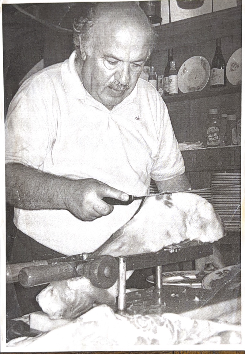 Ezio Salvi taglia il prosciutto a mano al coltello nella trattoria